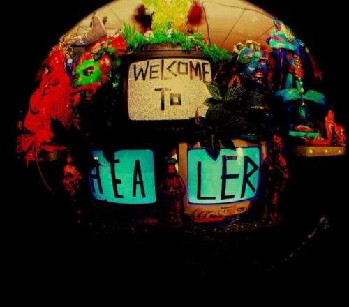 A colorful display featuring two old TVs with "WELCOME TO HEALER" written on them, surrounded by vibrant decorations.