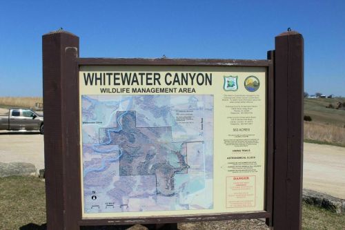 Sign for Whitewater Canyon Wildlife Management Area, featuring a map and information about the area and its trails.