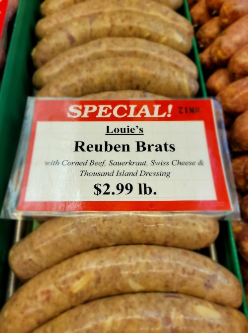 A display of Reuben Brats with a sign detailing ingredients and price: $2.99 per pound.