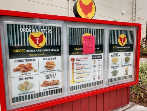 Menu board displaying chicken meal options, including jumbo tenders, big sammie, and chicken & waffles.