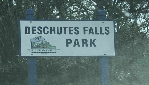 Sign for Deschutes Falls Park, located in Thurston County, featuring a mountain graphic and park name.