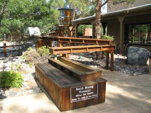 A wooden structure labeled "Smith Mining Company" with a gem mining area, surrounded by rocks and greenery.