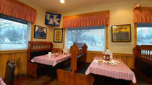 Cozy diner interior with checkered tablecloths, wooden booths, and Kentucky memorabilia on the walls.