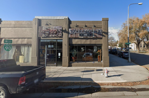 A street view of two storefronts, one featuring bicycles and the other labeled "Marketplace."