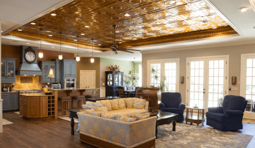 Spacious living area with a kitchen, elegant ceiling, cozy seating, and large windows letting in natural light.