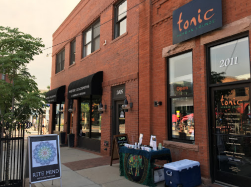 Exterior view of a brick building featuring Tonic Mexican Lounge and Rite Mind, with outdoor signage and a vibrant atmosphere.