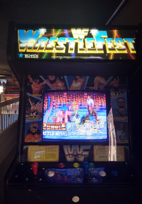 An arcade machine for WWF WrestleFest, featuring colorful graphics and a wrestling game display.