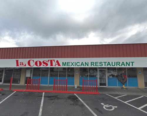 Exterior of La Costa Mexican Restaurant, featuring a red and green sign, with parking spaces in front.