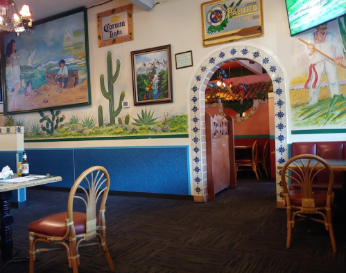 Interior of a colorful restaurant featuring murals, decorative arches, and cozy seating.