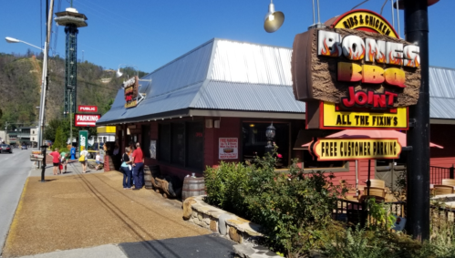 Exterior of Bones BBQ Joint with a sign, people outside, and a clear blue sky in the background.