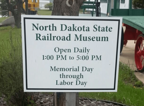 Sign for North Dakota State Railroad Museum, open daily from 1 PM to 5 PM, Memorial Day through Labor Day.