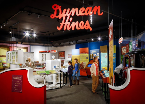 Exhibit showcasing Dunnean Hines with displays, artifacts, and visitors exploring the museum space.