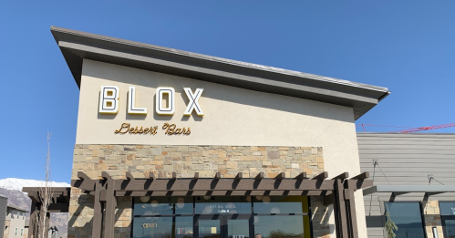 Sign for Blox Dessert Bar on a building with a clear blue sky in the background.
