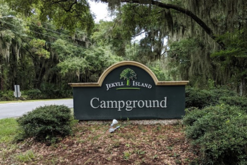 Sign for Jekyll Island Campground surrounded by trees and greenery.