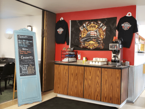 Cozy café corner with a specials board, coffee station, and wall art featuring a patriotic theme.