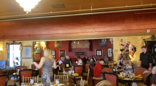 A bustling restaurant interior with diners at tables, colorful decor, and a lively atmosphere.