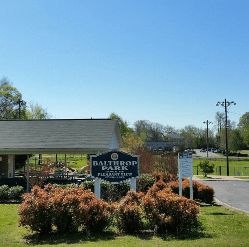 Sign for Balthrop Park in Pleasant View, Tennessee, with green grass and clear blue sky in the background.