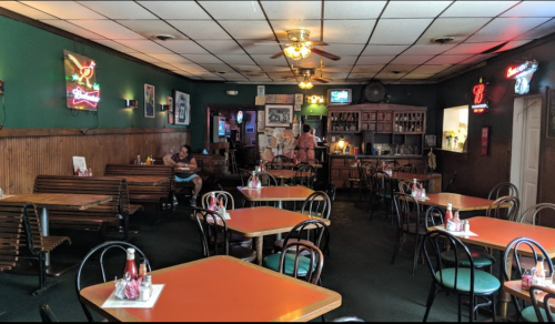 A cozy diner with wooden tables, neon signs, and a few patrons seated in a relaxed atmosphere.