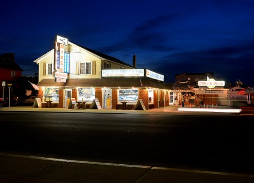 A seafood restaurant illuminated at night, featuring a brick exterior and bright signage.