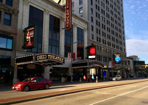 Exterior view of the Ohio Theatre and State Theatre, featuring marquee lights and a bustling street scene.