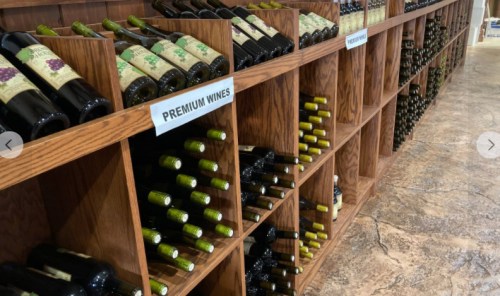A wooden wine rack displaying various bottles of premium wines, organized neatly on shelves.