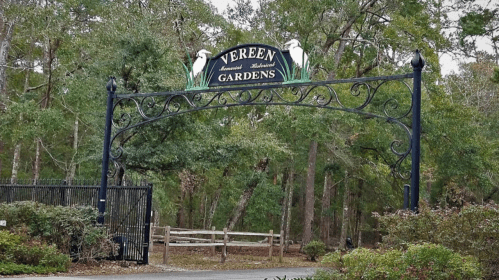 Entrance archway of Vereen Memorial Historical Gardens, surrounded by lush greenery and trees.