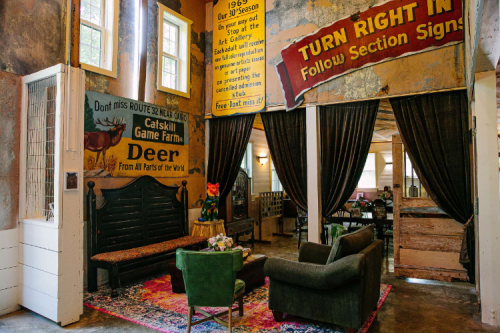 Cozy interior with vintage signs, a green sofa, and a rustic decor, creating a welcoming atmosphere.