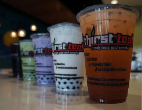 Four colorful cups of bubble tea from Thirst Tea, featuring various flavors and tapioca pearls.