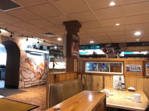 Interior of a cozy diner with wooden booths, decorative wall art, and a warm, inviting atmosphere.