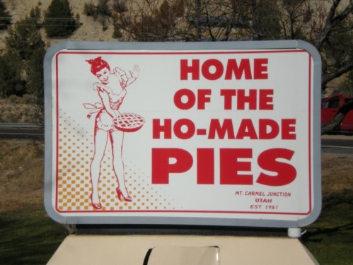 Sign reading "Home of the Ho-Made Pies" with a vintage illustration of a woman holding a pie, located in Mt. Carmel Junction, Utah.