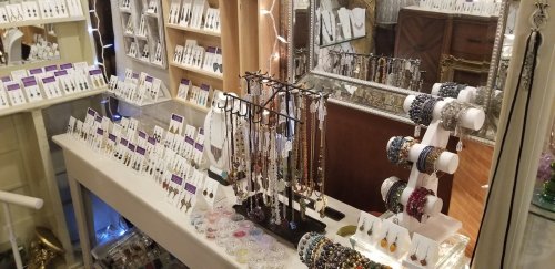 Display of various jewelry pieces, including necklaces, bracelets, and earrings, in a well-lit shop setting.