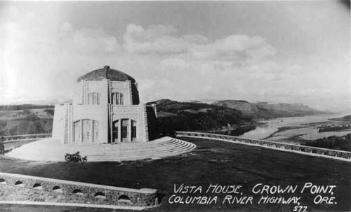 Historic Vista House at Crown Point, overlooking the Columbia River, with scenic views and a vintage motorcycle nearby.