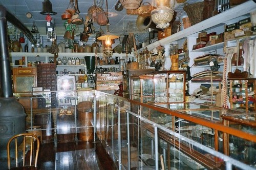 A vintage store interior filled with various antiques, jars, and baskets, showcasing a nostalgic atmosphere.