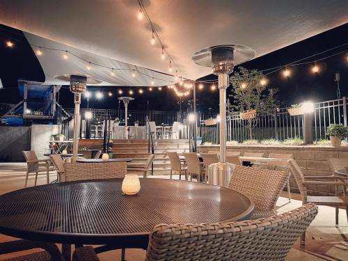 Cozy outdoor dining area at night, featuring string lights, patio heaters, and a warm ambiance.
