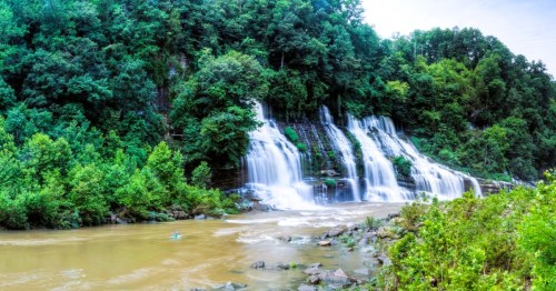 Views of a cascading waterfalls in a wooded area at Rock Island State Park in TN.