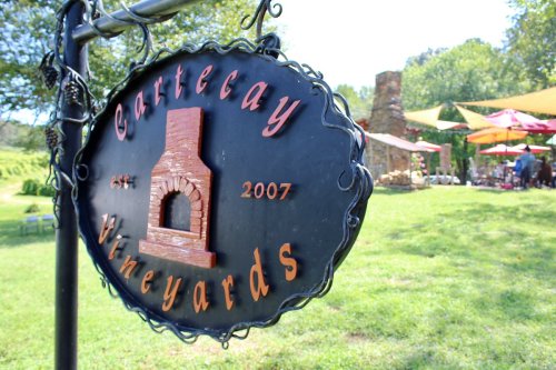 Sign for "Cartercay Vineyards" established in 2007, with a rustic design and a vineyard backdrop.