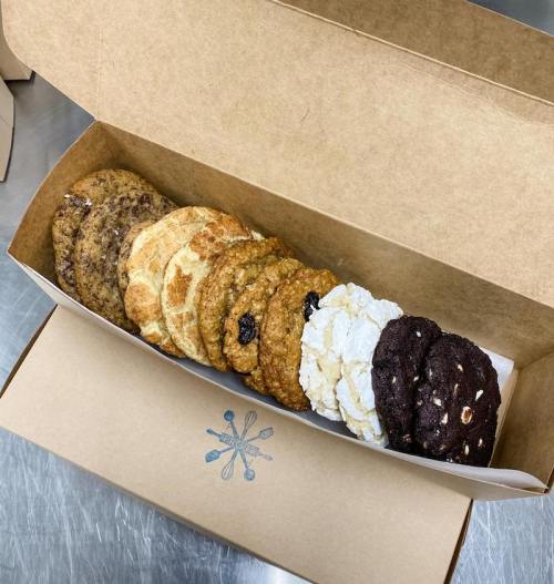 A box of assorted cookies, including chocolate, oatmeal, and snickerdoodle varieties, neatly arranged in a row.