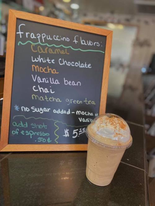A chalkboard menu lists frappuccino flavors: caramel, white chocolate, mocha, vanilla bean, chai, and matcha green tea.