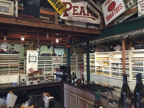 A cozy shop interior with shelves of jars, a wooden counter, and vintage signs, creating a warm, inviting atmosphere.