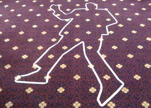 Outline of a person on a patterned carpet, resembling a crime scene chalk outline.