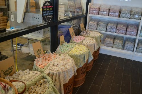 Baskets filled with colorful marshmallows in a shop, with jars of candy in the background.