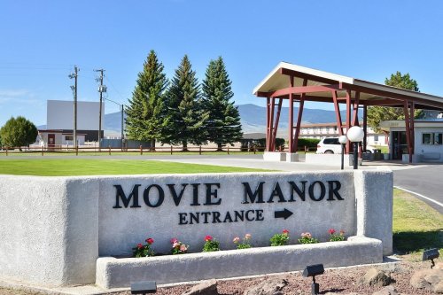 Sign for Movie Manor entrance with a clear blue sky and trees in the background.