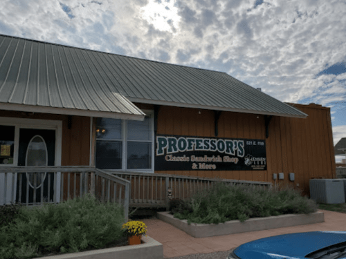 Exterior of Professor's Classic Sandwich Shop, featuring a wooden facade and a sign under a cloudy sky.