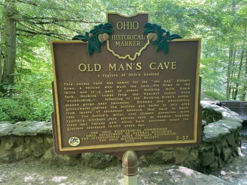 Historical marker for Old Man's Cave in Ohio, detailing its history and natural features.