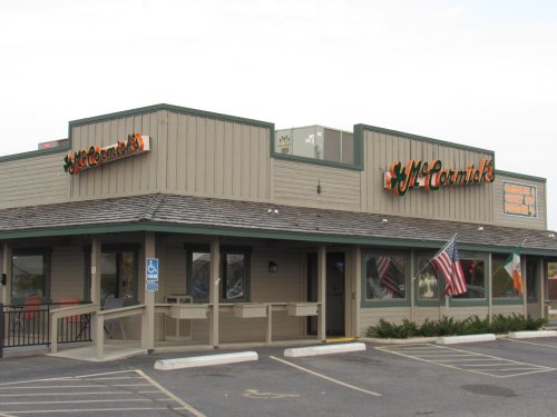 Exterior of McCormick's restaurant featuring a wooden facade, flags, and a sign with the restaurant's name.