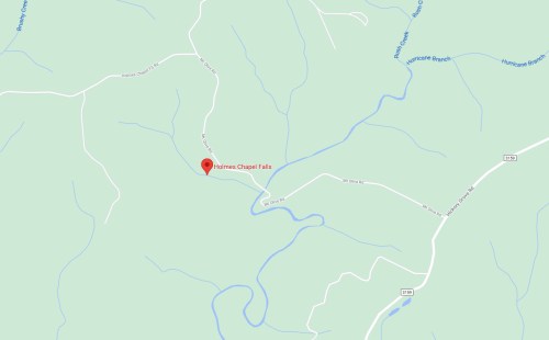 Map showing the location of Holmes Chapel Falls, surrounded by winding roads and waterways in a green landscape.
