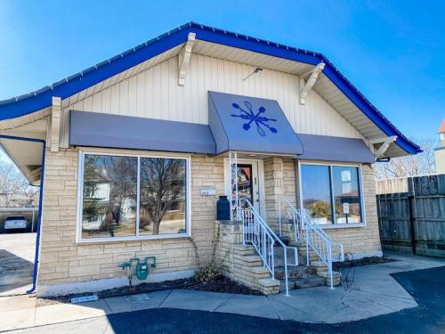 A light-colored building with a blue roof and awning, featuring large windows and a decorative snowflake logo.