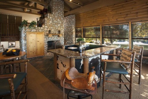Cozy interior featuring a stone fireplace, wooden accents, and a stylish kitchen island with bar seating.