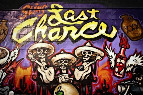 Colorful mural featuring skeletons in sombreros playing guitars, with the text "Last Chance" prominently displayed.