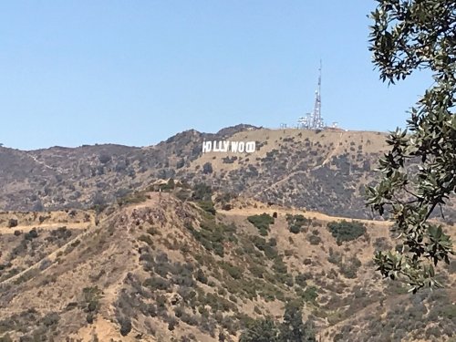 The iconic Hollywood sign on a hillside, with a clear blue sky in the background.